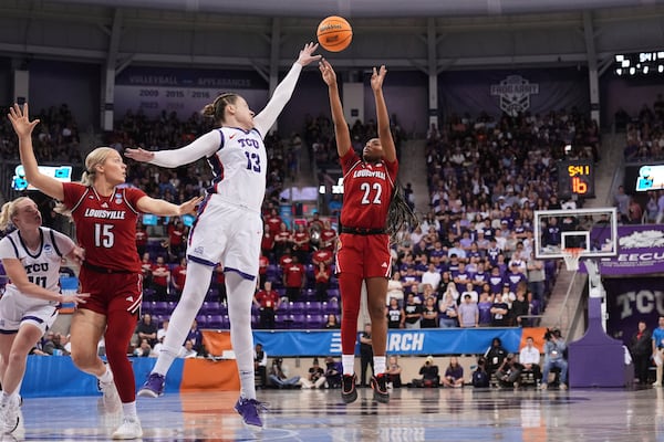 Louisville's Tajianna Roberts (22) shoots as TCU's Sedona Prince (13) defends in the first half in the second round of the NCAA college basketball tournament in Fort Worth, Texas, Sunday, March 23, 2025. (AP Photo/Tony Gutierrez)