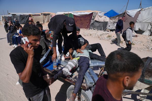 Palestinians carry an injured man after he was shot at an aid distribution center run by the Gaza Humanitarian Foundation a U.S.-backed organization approved by Israel in Khan Younis, southern Gaza Strip, on Thursday, May 29, 2025. (AP Photo/Abdel Kareem Hana)