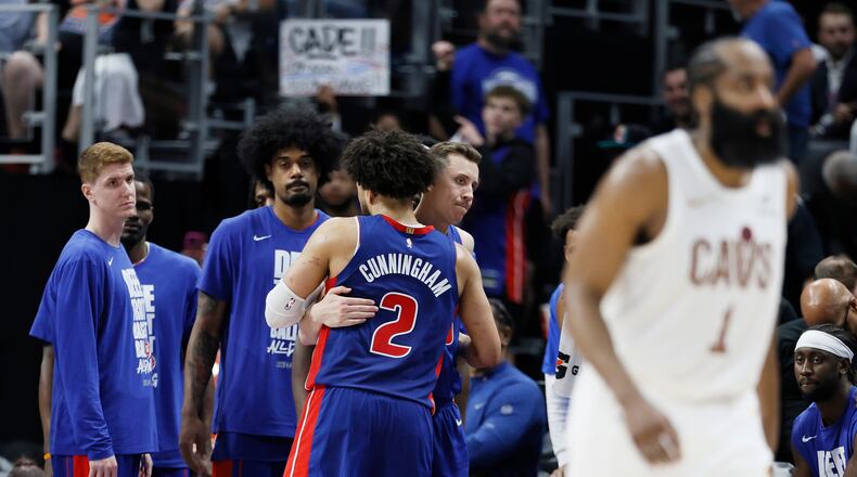 Detroit Pistons guard Cade Cunningham (2) is hugged by Duncan Robinson as Kevin Huerter, left, and Tolu Smith wait late in the fourth quarter of a loss to the Cleveland Cavaliers during Game 7 in a second-round NBA basketball playoffs series Sunday, May 17, 2026, in Detroit. (AP Photo/Duane Burleson)