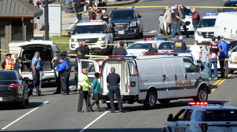 A woman, center, is taken into custody on Capitol Hill in Washington, Wednesday, March 29, 2017. Police say a driver struck a U.S. Capitol Police cruiser near the U.S. Capitol and was taken into custody.