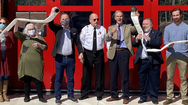 Cherokee County Fire Chief Tim Prather is joined by city and county officials at a hose uncoupling ceremony to officially open the new Fire Station 9 in Canton.