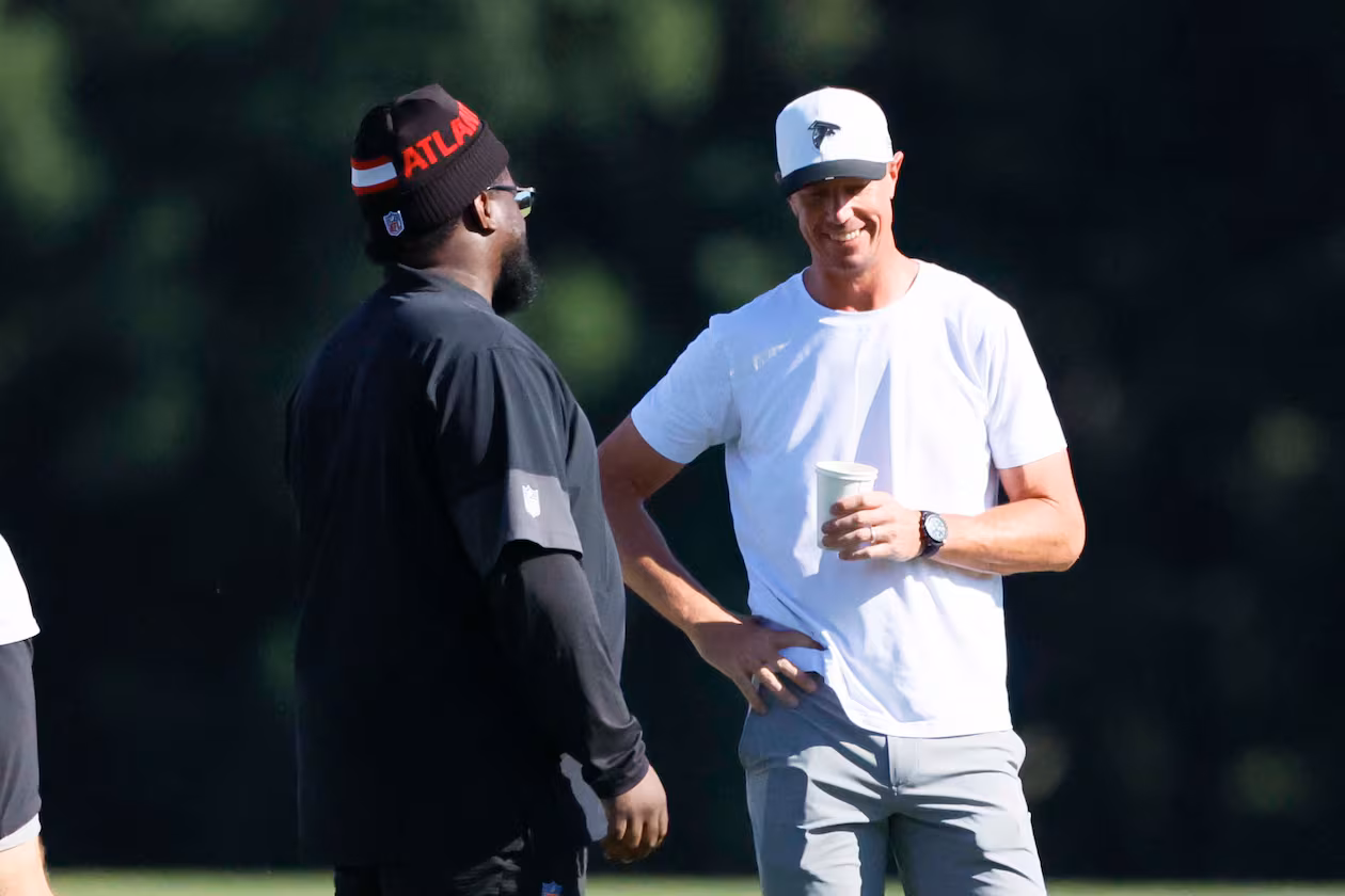 Former Atlanta Falcons quarterback Matt Ryan speaks with Falcons’ defensive line coach Nate Ollie during training camp at the Falcons Practice Facility on Sunday, July 27, in Flowery Branch, Ga. Falcons radio analyst Dave Archer thinks Ryan can help the team, particularly with young and developing quarterback Michael Penix Jr. (Miguel Martinez/AJC)