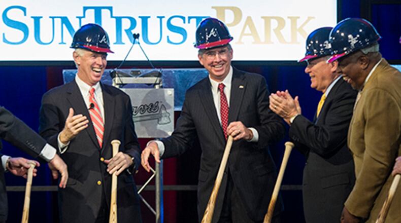 Cobb County chairman Tim Lee, left, Atlanta Braves chairman Terry McGuirk, second from left, SunTrust CEO William Rogers, third from left, Georgia Gov. Nathan Deal, second from right, and Hall of Fame baseball player Hank Aaron, right, wrap up a ground breaking ceremony Tuesday, Sept. 16, 2014, in Atlanta, for the Atlanta Braves new baseball stadium, which will be called SuntTust Park. The Braves will be moving from Turner Field in Fulton County to the new stadium being built in Cobb County in 2017. (AP Photo/John Amis)