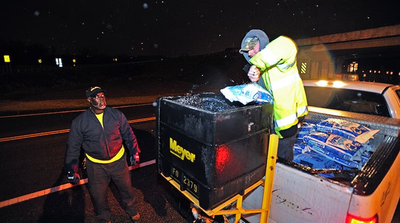 Richmond County workers John Johnson (left) and David Wilkey prepare to spread salt and sand on 5th Street in downtown Augusta on Wednesday, February 12, 2014. Georgia's so-called Garden City is preparing to be Ice City by morning, with thousands of homes losing power and felled trees shutting down roadways.