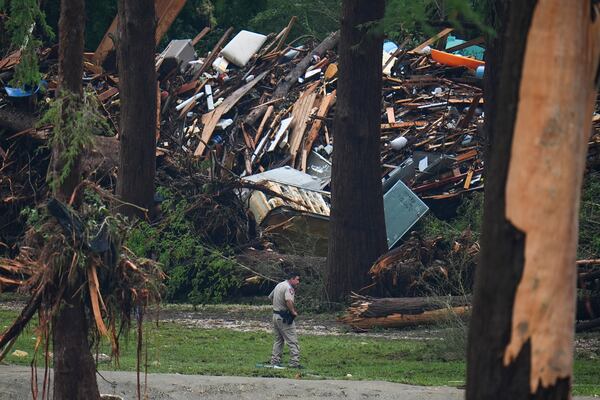 Officials comb through the banks of the Guadalupe River after a flash flood swept through the area Saturday, July 5, 2025, in Hunt, Texas. (AP Photo/Julio Cortez)