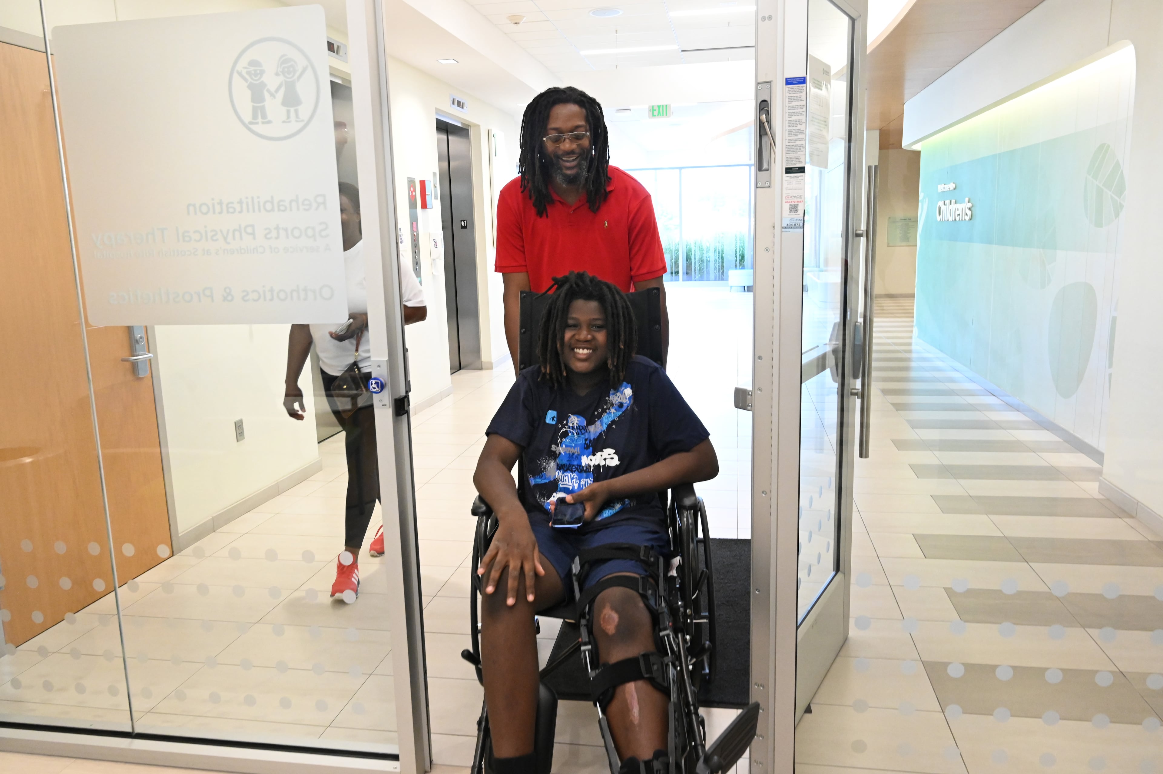Preston Veal, 12, arrives for his first physical therapy since he was struck by a cargo van as his parents, Bernice and Damien Veal, accompany him at Children's Healthcare of Atlanta Orthopedics and Sports Medicine in Kennesaw. (Hyosub Shin/AJC)