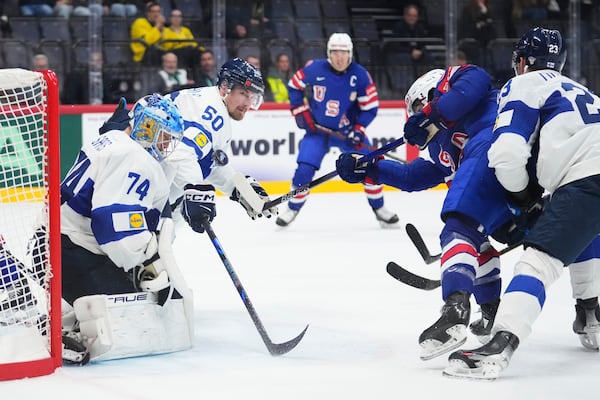 The United States' Conor Garland, second from right, scores a goal against Finland's Juuse Saros (74), Mikael Seppala (50) and Nikolas Matinpalo, right, during the second period of a quarterfinal match at the ice hockey world championships in Stockholm, Sweden, Thursday, May 22, 2025. (AP Photo/Petr David Josek)