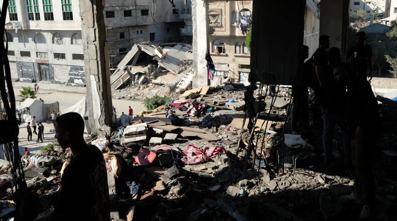 Residents inspect the site of an Israeli airstrike in Gaza city, Saturday, July 18, 2026. (AP Photo/Jehad Alshrafi)