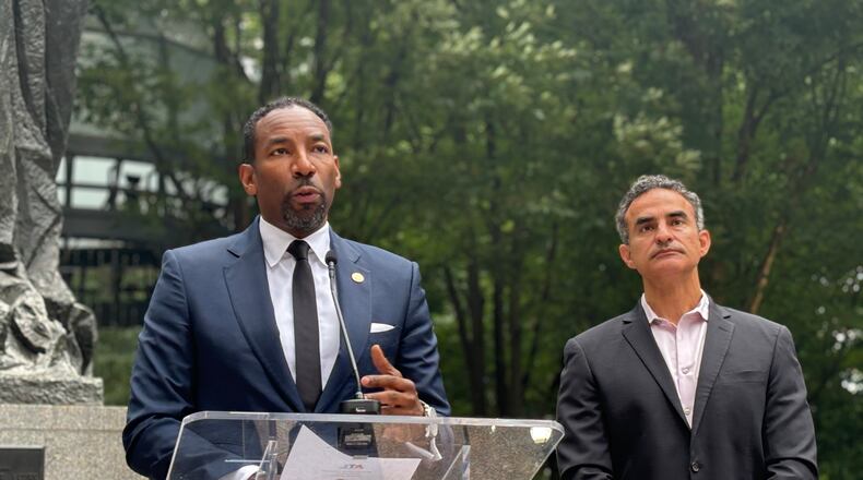 Mayor Andre Dickens (left) announces $60 million in public funding for homelessness at an event at Woodruff Park on Monday, Sept. 3, 2024. Frank Fernandez, President and CEO at Community Foundation for Greater Atlanta ,(right) said his group had committed $10 million to the effort.