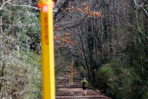 A jogger exercises at the intramural fields as he approaches an emergency call station on the east side of the UGA campus on Tuesday, Feb. 18, 2025. One year after the murder of Laken Riley, the University of Georgia has allocated millions of dollars toward safety enhancements. (Miguel Martinez/AJC)