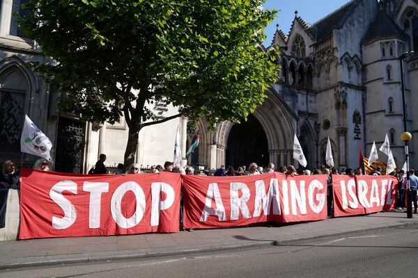Demonstrators gather outside the Royal Courts of Justice in London, where Palestinian human rights organization Al-Haq is taking legal action against the Department for Business and Trade over several decisions, Tuesday May 13, 2025. (Ben Whitley/PA via AP)