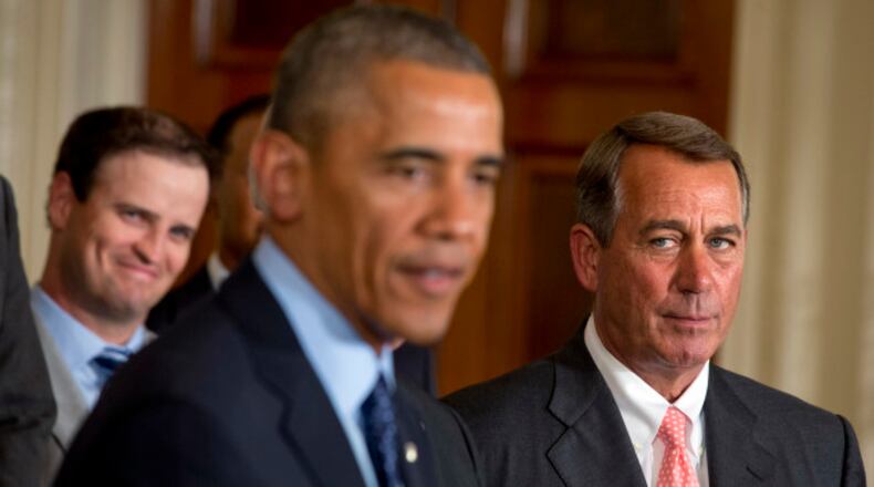 House Speaker John Boehner, R-Ohio, right, watches President Barack Obama speak, as golfer Zach Johnson watches at left, during a ceremony honoring the 2013 Presidents Cup U.S. team during a ceremony in the East Room of the White House, Tuesday, June 24, 2014 in Washington. The U.S. team beat an international squad during the Presidents Cup matches in October 2013. (AP Photo/Jacquelyn Martin)
