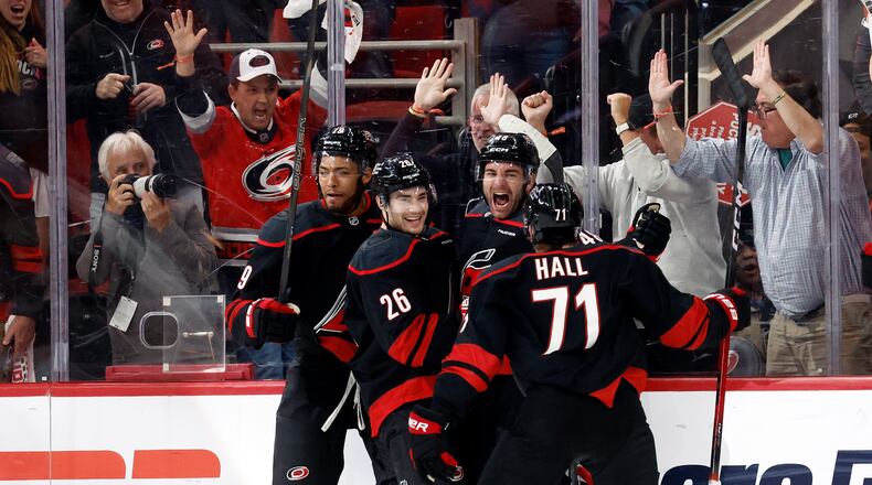 Carolina Hurricanes' Jordan Martinook, second from right, celebrates after his winning overtime goal with Sean Walker (26), Taylor Hall (71) and K'andre Miller (19) following the second overtime of Game 2 of an NHL hockey Stanley Cup first-round playoff series against the Ottawa Senators in Raleigh, N.C., Monday, April 20, 2026. (AP Photo/Karl DeBlaker)