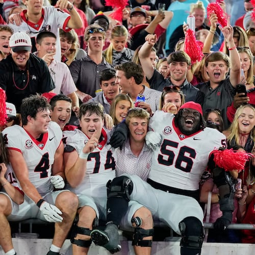 Georgia players tight end Oscar Delp (4), offensive lineman Drew Bobo (74) and offensive lineman Micah Morris (56) celebrate with fans after defeating Florida in an NCAA college football game Saturday, Nov. 1, 2025, in Jacksonville, Fla. (AP Photo/John Raoux)
