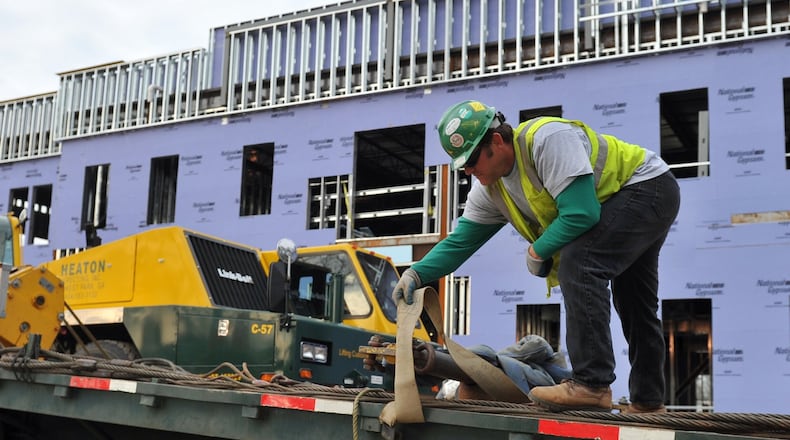 Scott Elliott with Heaton Erecting of Forest Park works a new construction project at the Georgia Military College in Fairburn Thursday March 27, 2014. The company lifted a HVAC unit onto the roof of the building. BRANT SANDERLIN /BSANDERLIN@AJC.COM