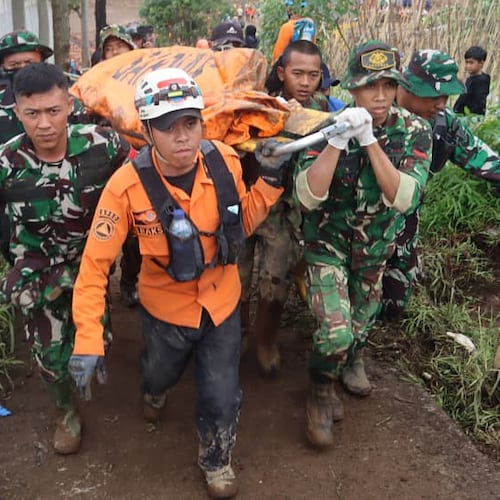In this photo released by Indonesia's National Disaster Management Agency (BNPB) rescuers carry the body of a victim of landslide at Pasir Langu village after a landslide, in West Bandung district of West Java province, Indonesia, Monday, Jan. 26, 2026. (BNPB via AP)