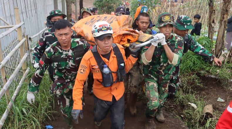 In this photo released by Indonesia's National Disaster Management Agency (BNPB) rescuers carry the body of a victim of landslide at Pasir Langu village after a landslide, in West Bandung district of West Java province, Indonesia, Monday, Jan. 26, 2026. (BNPB via AP)