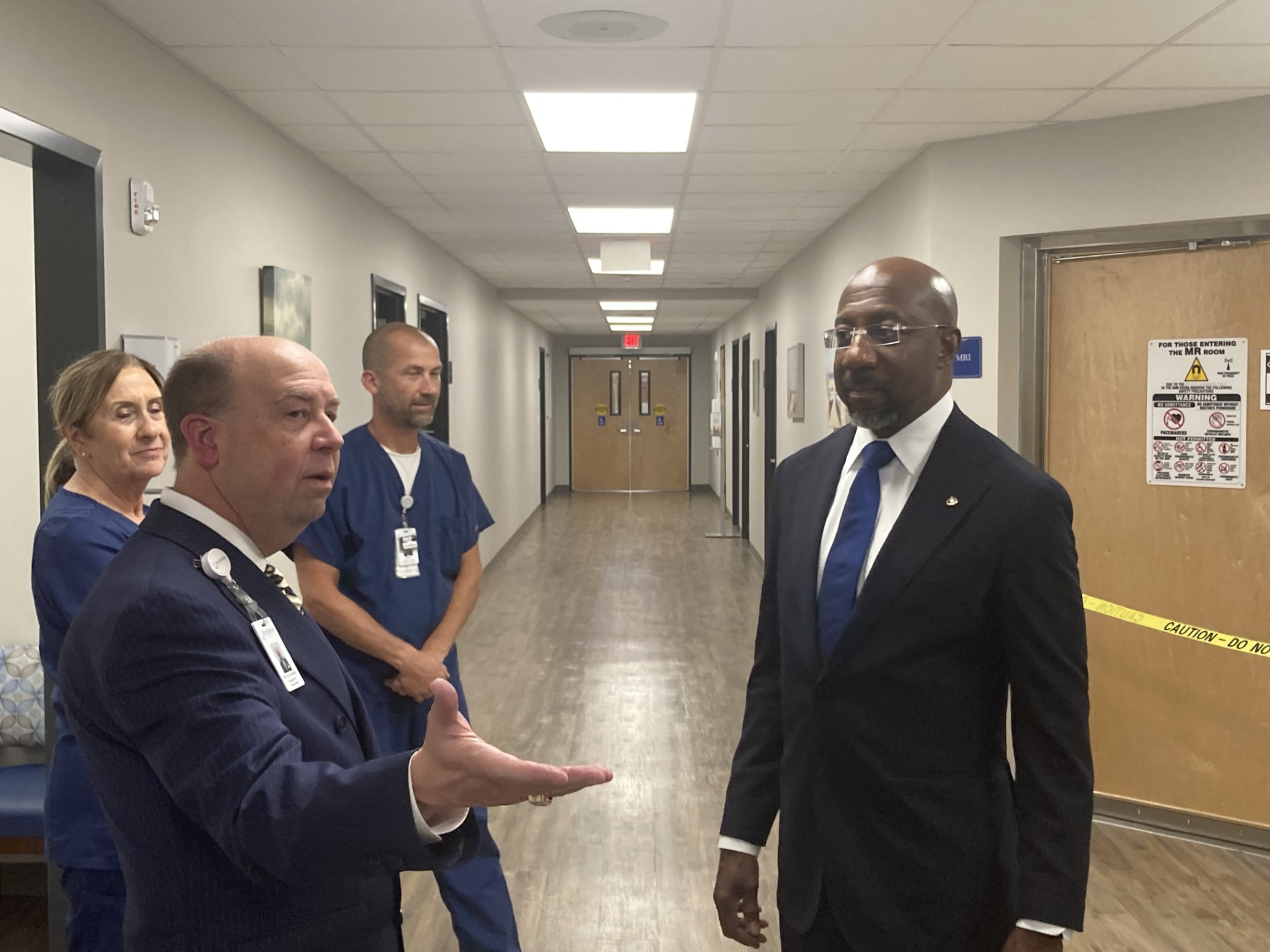 Evans Memorial Hospital CEO Bill Lee, left, leads U.S. Sen. Raphael Warnock, D-Ga., on a tour of the medical center. (Adam Van Brimmer/AJC)