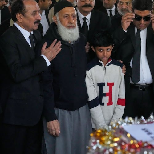 Mourners comfort Yahya Zubair, son of lawyer Zubair Aslam Ghumman, who was killed in Tuesday's suicide bombing outside the gates of a district court, during a funeral prayer, in Islamabad, Pakistan, Wednesday, Nov. 12, 2025. (AP Photo/Anjum Naveed)