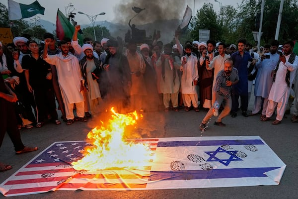 Shiite Muslims burn representations of U.S. and Israeli flags during a rally to condemn Israeli strikes on Iran, in Islamabad, Pakistan, Tuesday, June 17, 2025. (AP Photo/Anjum Naveed)