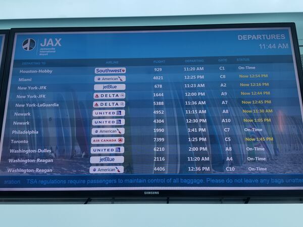 A flight information display shows delayed flights on January 25, 2019 at Jacksonville International Airport. The delays were caused by shortages of air traffic controllers at two major Federal Aviation Administration facilities.