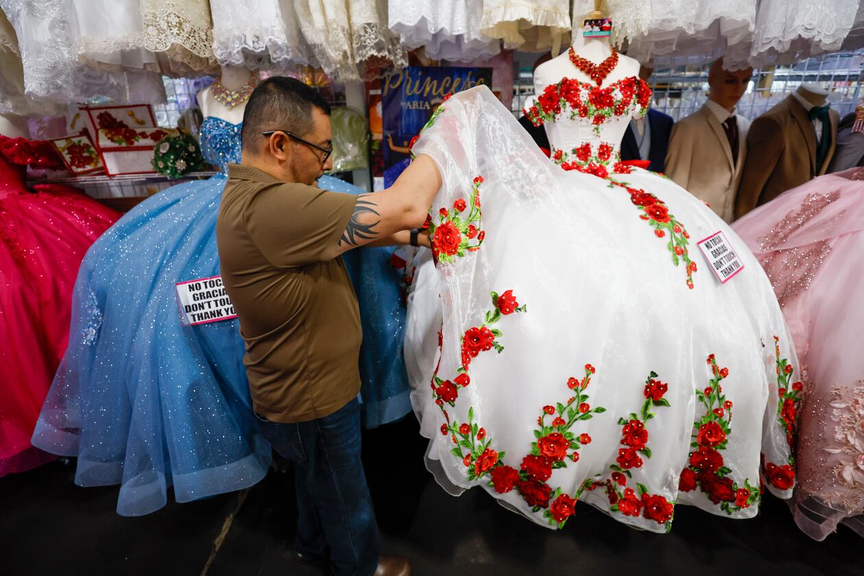 Frank Chavez, owner of Lizzy Fashion, arranging a quinceañera dress at his shop in Plaza Fiesta on Wednesday, May 7, 2025. (Miguel Martinez/AJC)