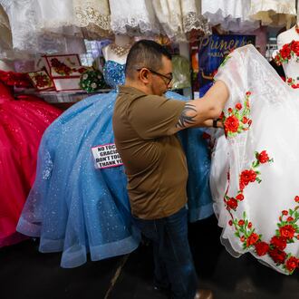 Frank Chavez, owner of Lizzy Fashion, arranging a quinceañera dress at his shop in Plaza Fiesta on Wednesday, May 7, 2025. (Miguel Martinez/AJC)