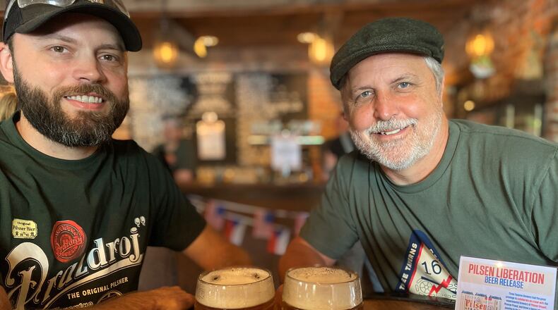 At Three Taverns in Decatur, head brewer Neal Engleman (left) and founder/CEO Brian Purcell share mugs of Pilsen Liberation.
Bob Townsend for The Atlanta Journal-Constitution