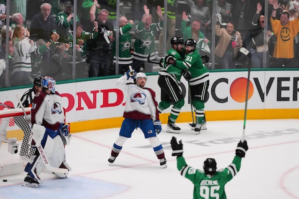 Colorado Avalanche goaltender Mackenzie Blackwood (39) and Samuel Girard, center, look on as the Dallas Stars celebrate a goal scored by Dallas Stars' Mikko Rantanen, rear, in the third period in Game 7 of a first-round NHL hockey playoff series Saturday, May 3, 2025, in Dallas. (AP Photo/Julio Cortez)