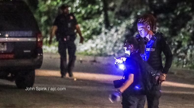 Atlanta police gather evidence at the scene of a deadly shooting on Third Avenue in southwest Atlanta on Tuesday morning.