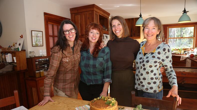 Asheville, N.C., culinarians Ashley English (from left), Ashley Capps, Susannah Gebhart and Barbara Swell recently spent an afternoon in Swell’s kitchen baking and assembling an apple stack cake, a traditional Appalachian dessert of thick dried apple filling spread between layers of sorghum-sweetened cake. Although the women are longtime friends, they had never all cooked together. TYSON HORNE / TYSON.HORNE@AJC.COM