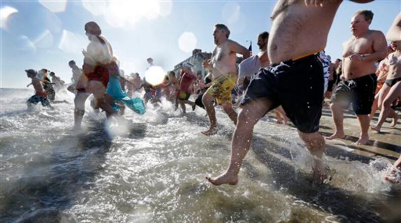 People run into the cold Atlantic Ocean during the Sons of Ireland's annual New Year's Day Polar Bear Plunge on a sunny, but frigid Thursday, Jan. 1, 2015, in Asbury Park, N.J. (AP Photo/Mel Evans)