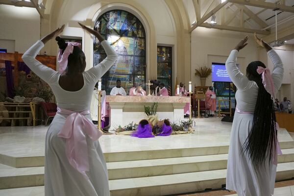 Members of the "mimers" youth group dance before the altar as Rev. Reginald Jean-Mary diffuses incense on it before Mass at Notre Dame d'Haiti Catholic church, March 29, 2025, in Miami. (AP Photo/Giovanna Dell'Orto)