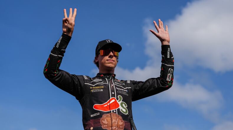 Carson Hocevar holds up eight fingers in honor of late driver Kyle Busch prior to a NASCAR Cup Series auto race, Sunday, May 24, 2026, in Charlotte, N.C. (AP Photo/Matt Kelley)