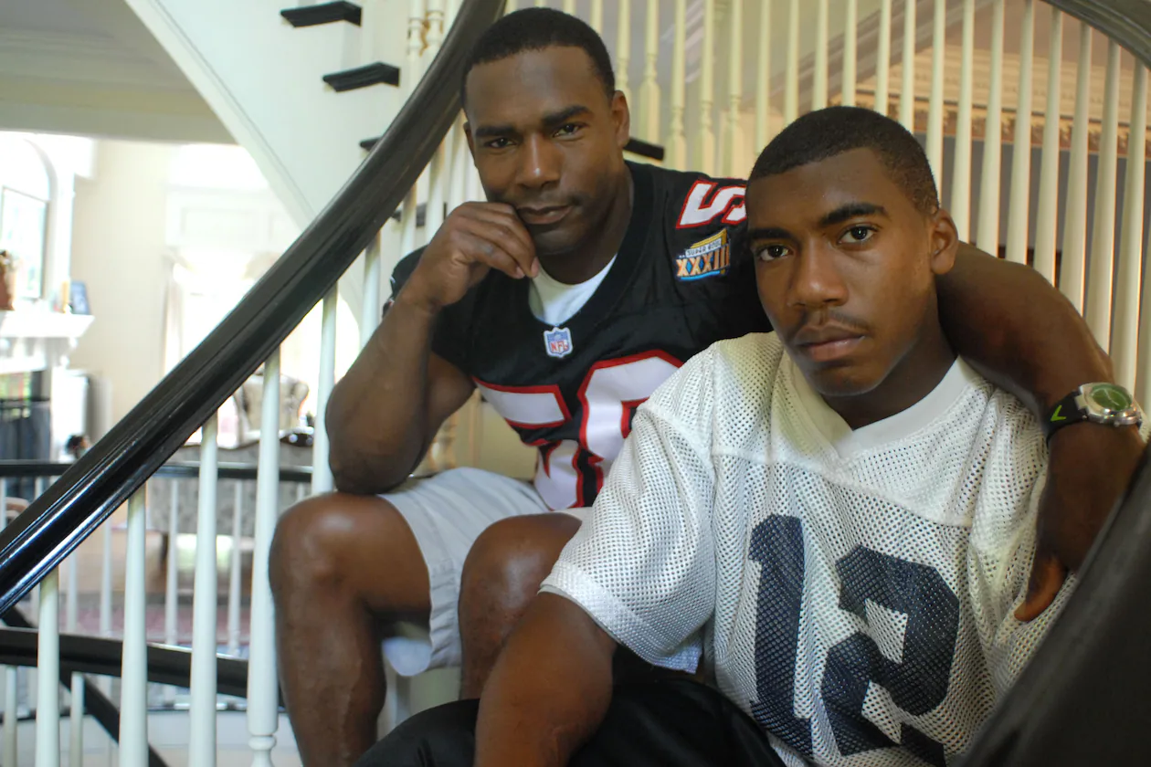 Former Falcons linebacker Jessie Tuggle (left) with his son Justin Tuggle, when Justin was a senior and quarterback at Northview High School. Justin Tuggle was named one of the Falcons' four Bill Walsh Diversity Coaching Fellows. (Renee Brock/AJC file)