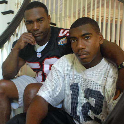 Former Falcons linebacker Jessie Tuggle (left) with his son Justin Tuggle, when Justin was a senior and quarterback at Northview High School. Justin Tuggle was named one of the Falcons' four Bill Walsh Diversity Coaching Fellows. (Renee Brock/AJC file)