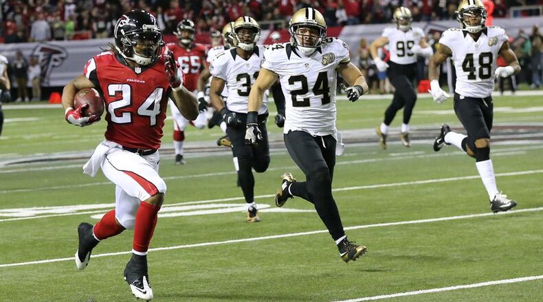 Falcons running back Devonta Freeman breaks away from Saints defenders for a 75-yard touchdown run to take a 14-3 lead during the first quarter Sunday, Jan. 1, 2017, at the Georgia Dome in Atlanta. (ccompton@ajc.com/ccompton@ajc.com)