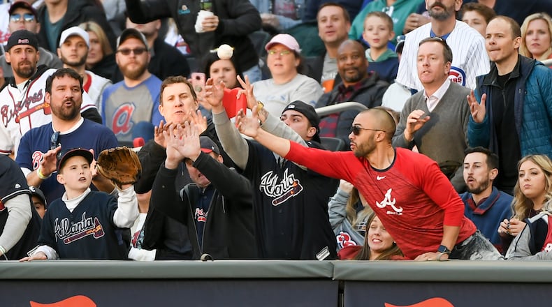 Braves fans reach for a foul ball at a game early this season.