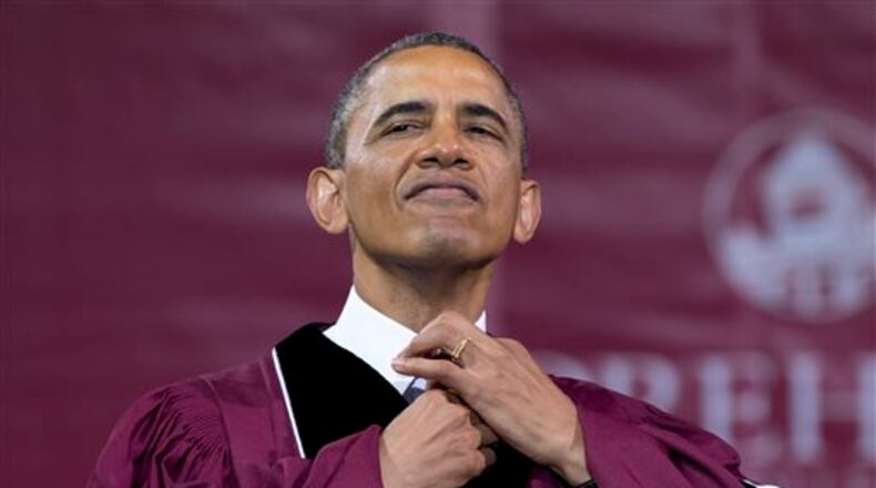 President Barack Obama straightens his tie before he receives an honorary doctorate of laws degree during the Morehouse College 129th Commencement ceremony on May 19, 2013, in Atlanta.