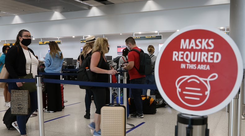 A sign reading, 'masks required in this area,' is seen as travelers prepare to check-in for their Delta Air Lines flight at the Miami International Airport on Feb. 1, 2021 in Miami, Florida. (Joe Raedle/Getty Images/TNS)