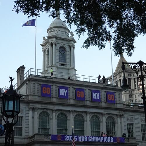 Banners hang above City Hall as preparations take place, Wednesday, June 17, 2026, in New York, ahead of the New York Knicks' NBA championship ticker-tape parade. (AP Photo/Alyssa Goodman)