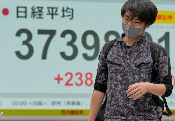 A person walks in front of an electronic stock board showing Japan's Nikkei index at a securities firm Monday, May 26, 2025, in Tokyo. (AP Photo/Eugene Hoshiko)