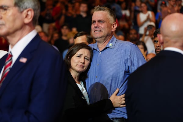 Shari and Stephen Feehan, the parents of 1st Lt. Tyler James Feehan, are understandably emotional as President Trump talks about their son at Wheeler High School on July 22, 2026. (Julia Demaree Nikhinson/AP)
