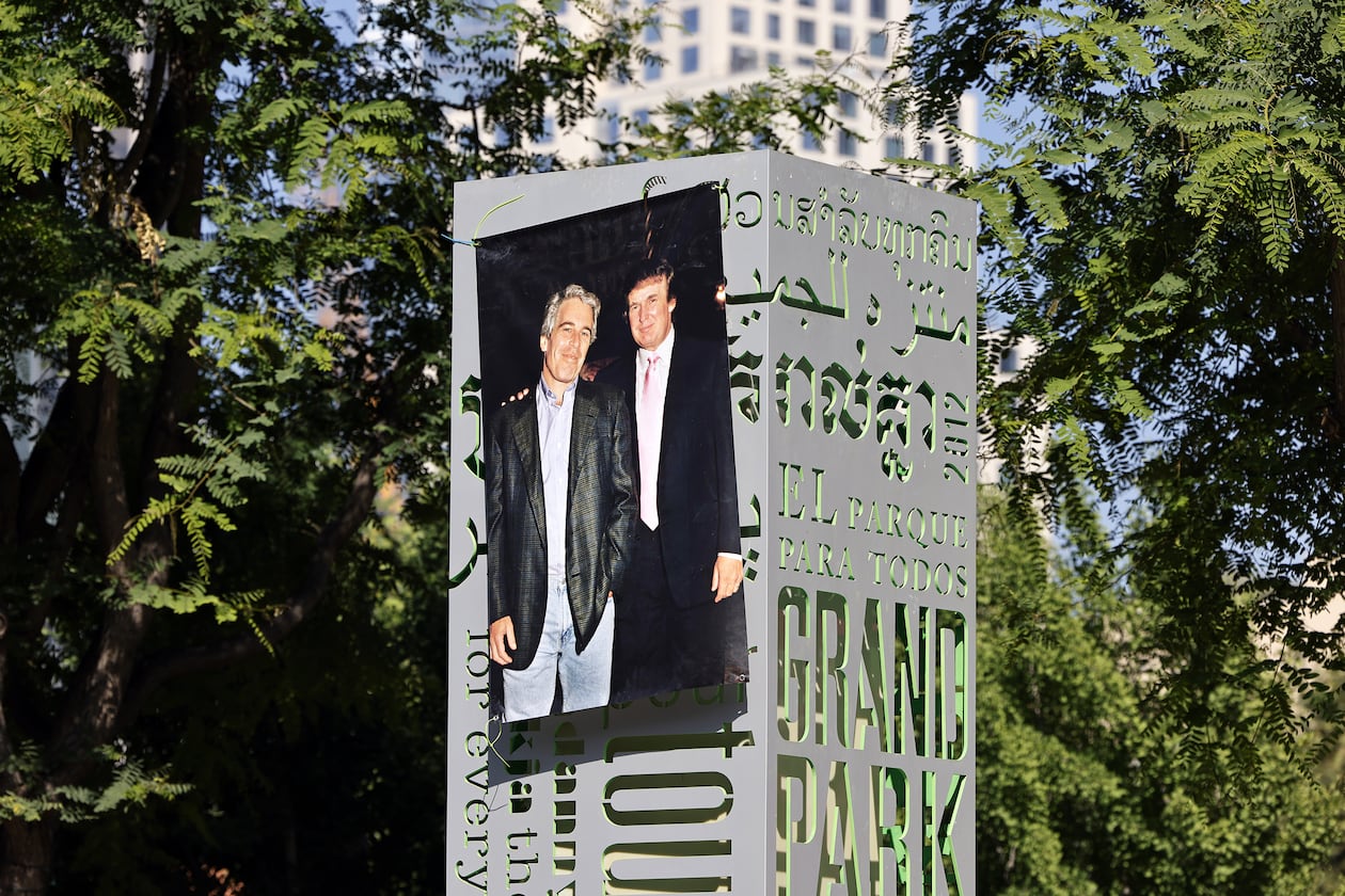 A 1997 photograph of the late Jeffrey Epstein (left) and Donald Trump was posted on a sign at Gloria Molina Grand Park in Los Angeles in June. (TNS)