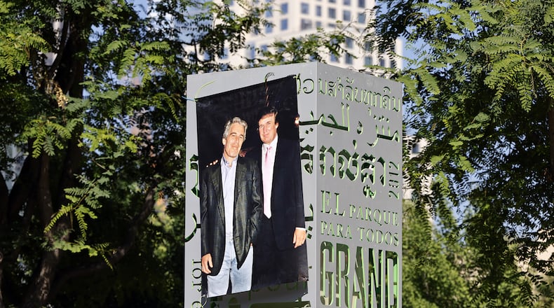 A 1997 photograph of the late Jeffrey Epstein (left) and Donald Trump was posted on a sign at Gloria Molina Grand Park in Los Angeles in June. (TNS)