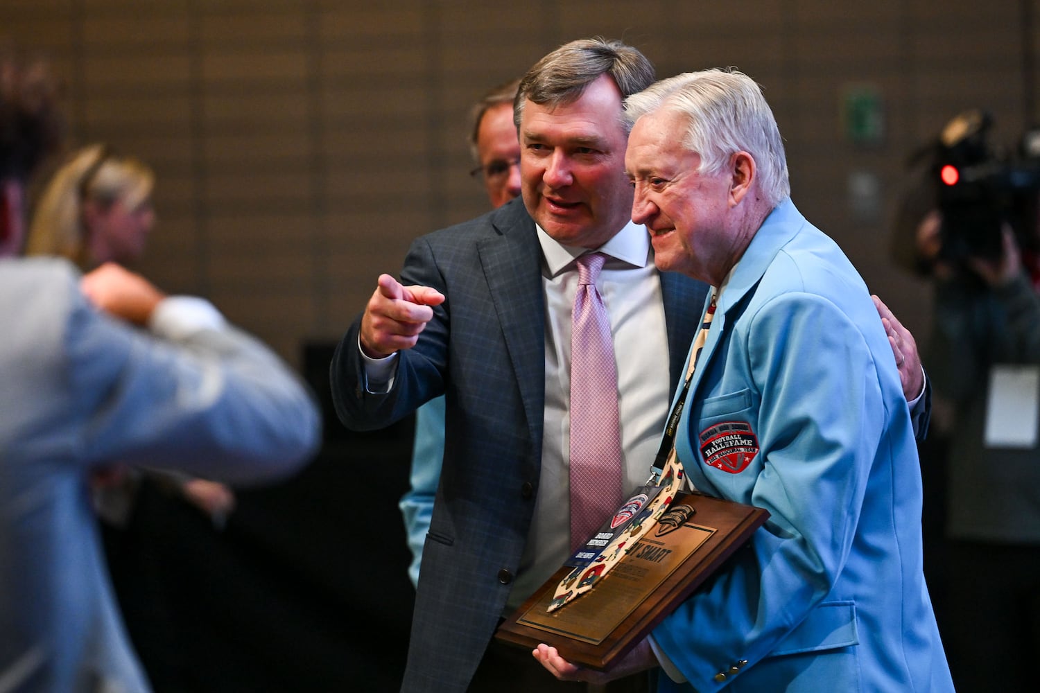 Georgia football head coach Kirby Smart (left) is presented his plaque from Dave Hunter, co-chairman of the Georgia High School Football Hall of Fame association, after being inducted to the Hall of Fame Saturday, Oct. 25, 2025, at the College Football Hall of Fame in Atlanta. (Daniel Varnado for the AJC)