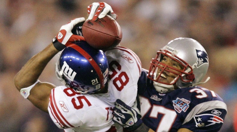 In this Feb. 3, 2008 file photo, New York Giants receiver David Tyree (85) catches a 32-yard pass in the clutches of New England Patriots safety Rodney Harrison (37) during the fourth quarter of the Super Bowl XLII football game at University of Phoenix Stadium in Glendale, Ariz. (AP Photo/Gene Puskar/FILE)