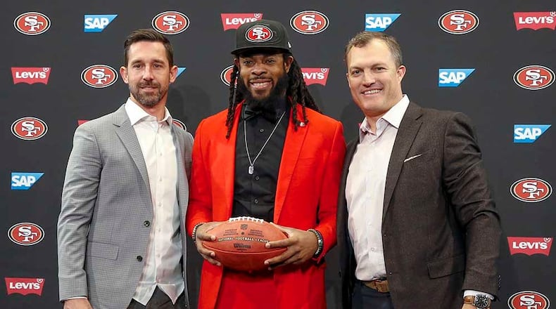 San Francisco 49ers head coach Kyle Shanahan, left, cornerback Richard Sherman, center, and general manager John Lynch, right, pose for a photo before an NFL football news conference in Santa Clara, Calif., Tuesday, March 20, 2018. Sherman agreed to a three-year deal with the 49ers. (AP Photo/Tony Avelar) ORG XMIT: CATA101