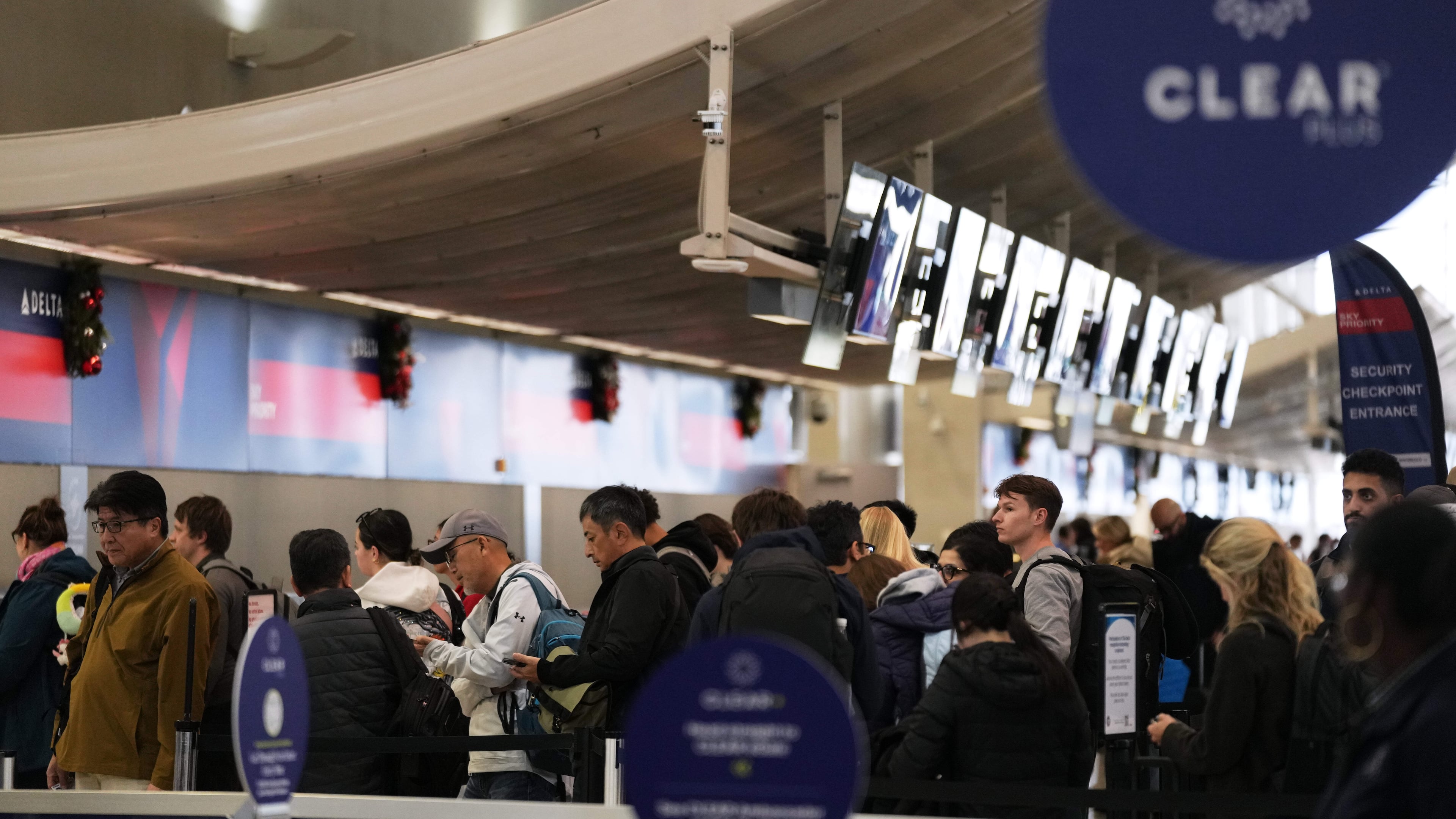 Travelers wait in a TSA checkpoint at Detroit Metropolitan Wayne County Airport Wednesday, Nov. 26, 2025, in Romulus, Mich. (AP Photo/Ryan Sun)
