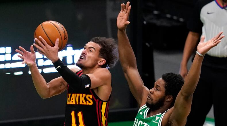 Atlanta Hawks guard Trae Young (11) drives past Boston Celtics forward Semi Ojeleye during the second half of an NBA basketball game, Wednesday, Feb. 17, 2021, in Boston.